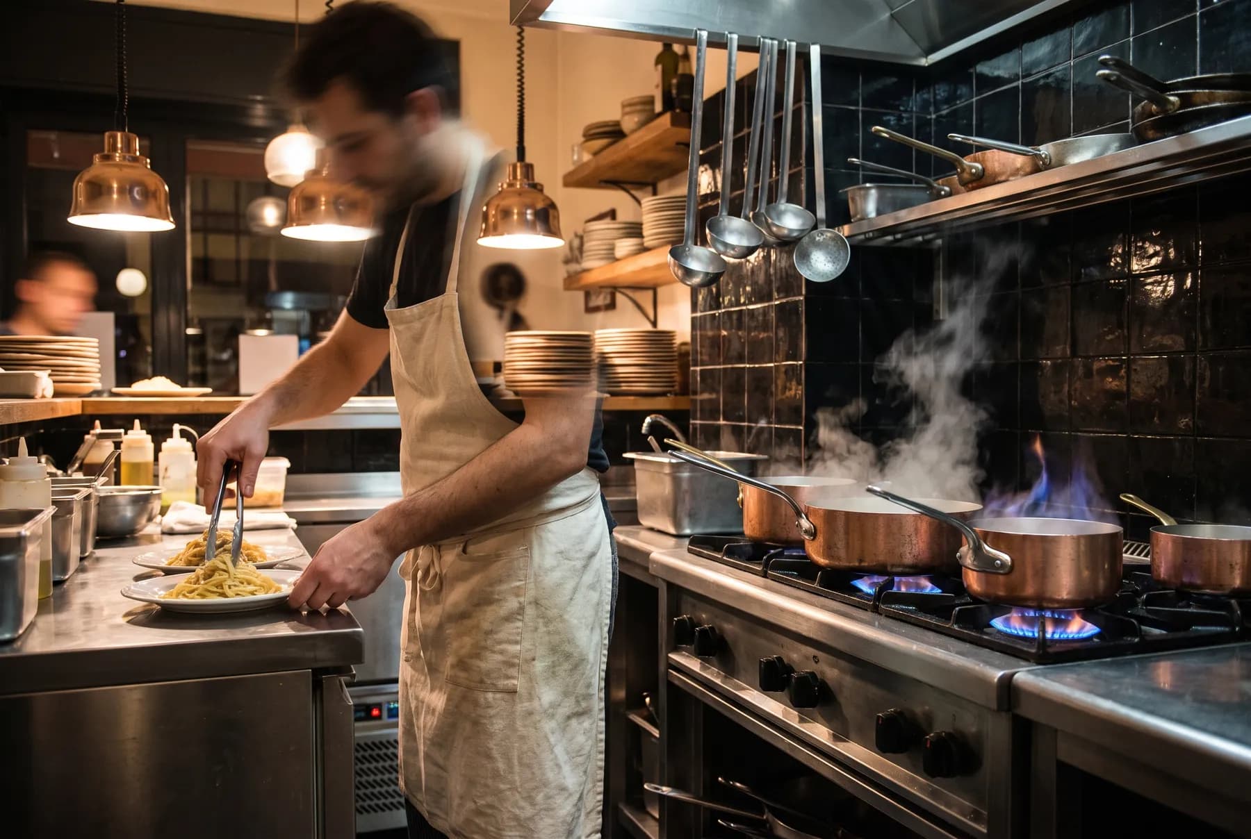 La cucina a vista durante il servizio serale, con le pentole di rame sul fuoco